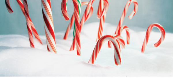 candy canes propped in snow on blue background