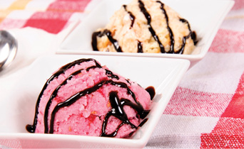 scoop of strawberry and vanilla ice cream drizzled with chocolate