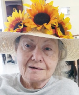 older adult woman pictured with her home-made Kentucky Derby hat decorated with sunflowers