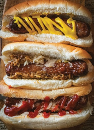 Three Bratwurst loaded with toppings, mustard, ketchup